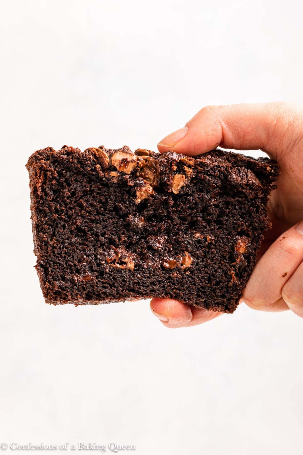 hand holding a slice of chocolate bread up to the camera